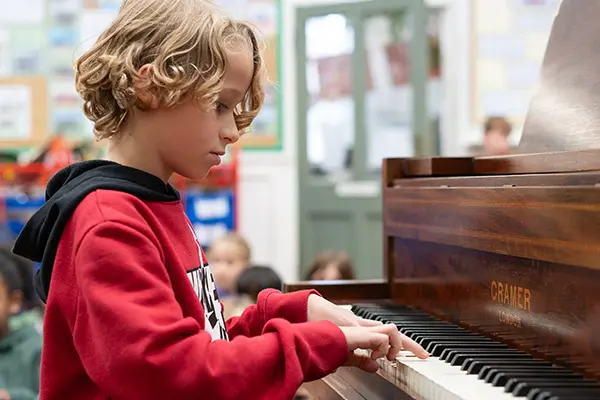 Boy playing piano in class